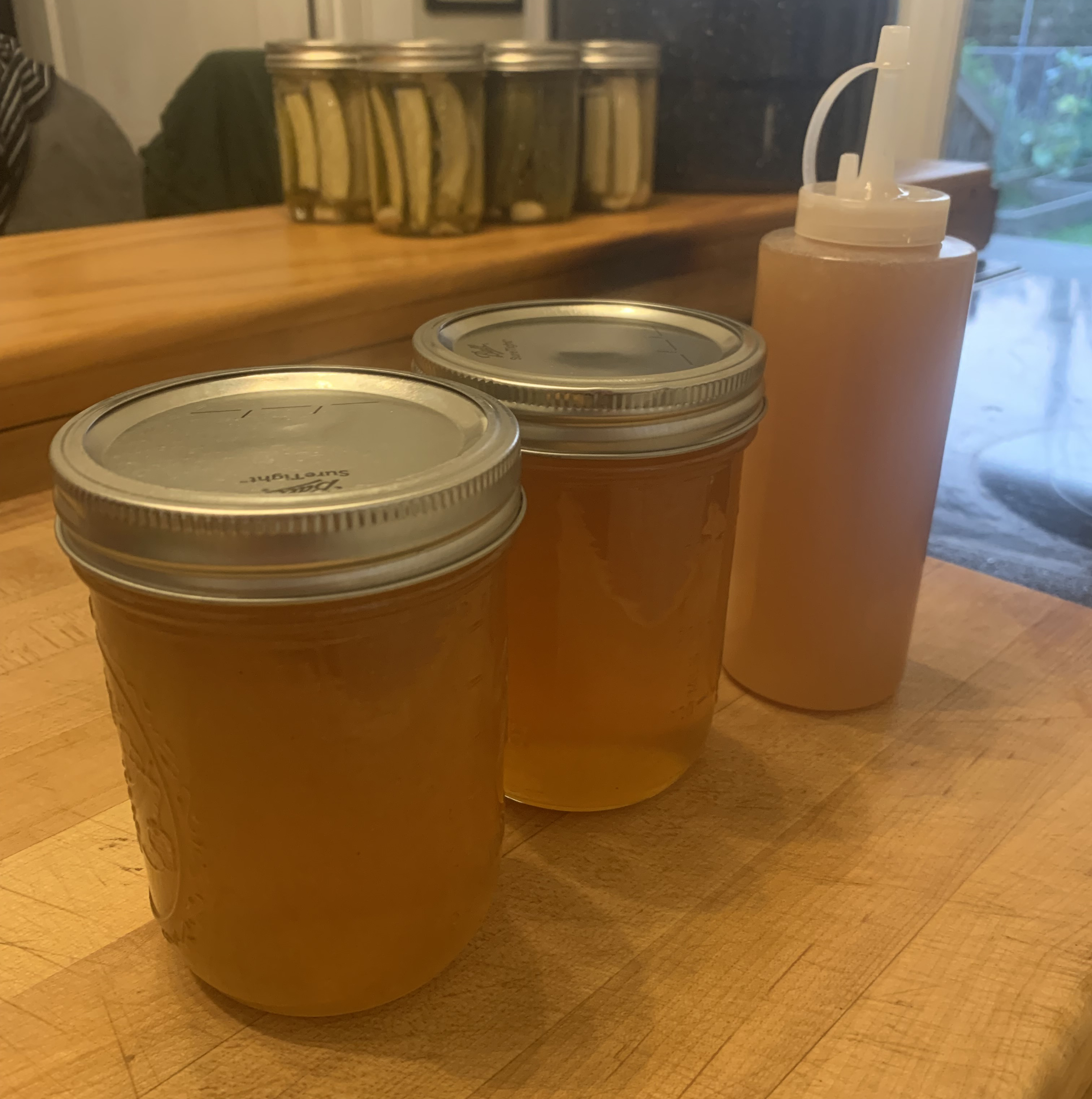 two jars and a squeeze bottle of honey